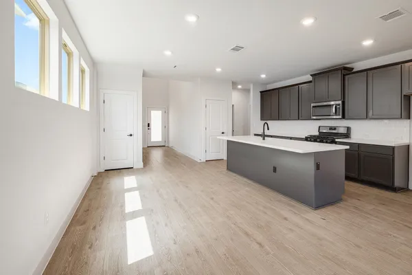 a kitchen with kitchen island granite countertop a sink and cabinets