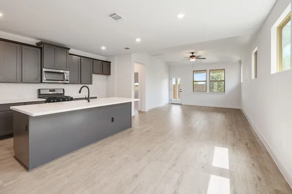 a kitchen with kitchen island granite countertop a sink window and cabinets