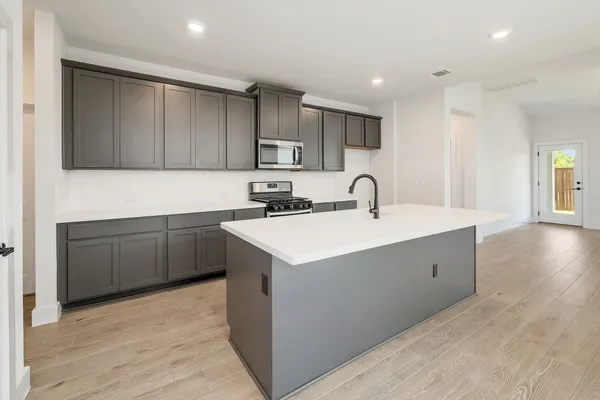 a kitchen with a sink cabinets and wooden floor