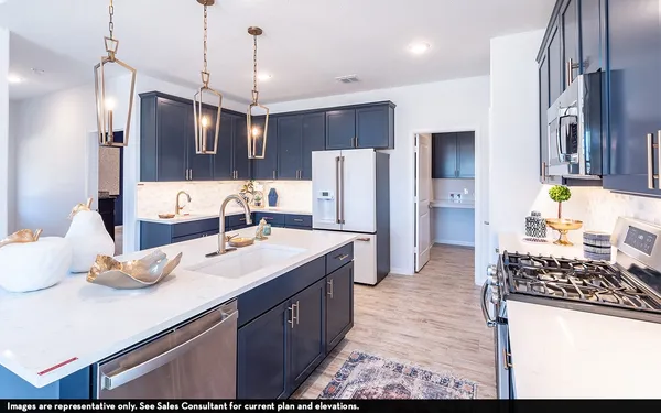 a kitchen with stainless steel appliances kitchen island granite countertop a sink stove and refrigerator