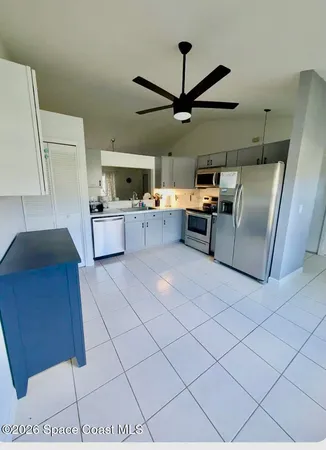 a kitchen with stainless steel appliances kitchen island granite countertop a refrigerator and a stove top oven