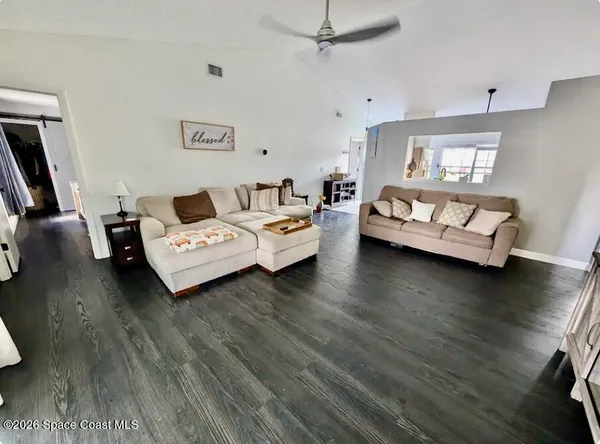 a living room with furniture and wooden floor