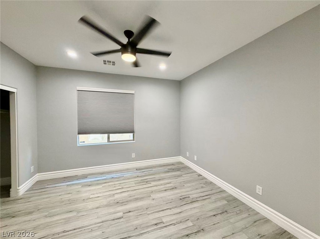 135 Tall Ruff Drive Las Vegas, NV 89148 - Photo 9 of 29 Well-lit room featuring light plank flooring and a modern ceiling fan.