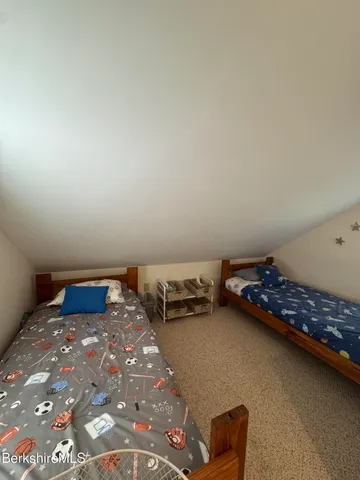 a bed sitting in a bedroom next to a window