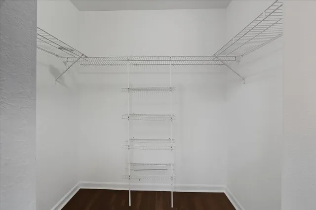 a view of walk in closet with empty racks