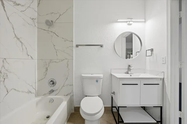 a bathroom with a toilet sink and mirror