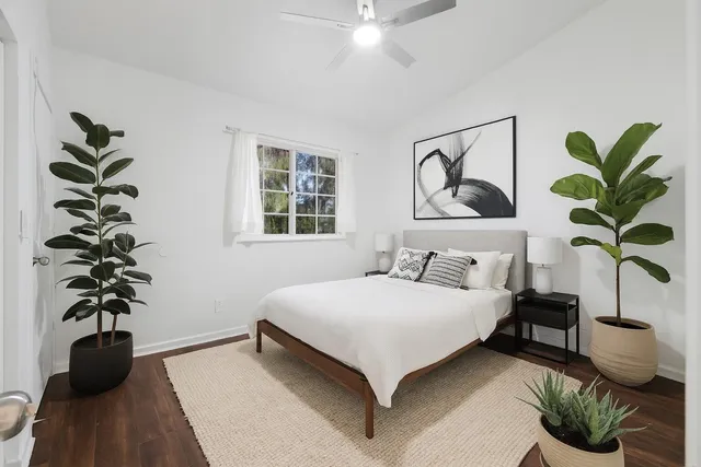 a bedroom with a bed and a potted plant