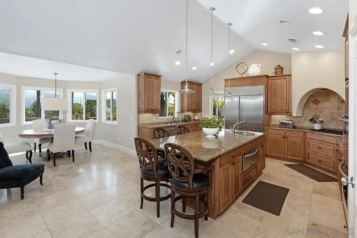14258 Palisades Drive Poway, CA 92064 - Photo 9 of 40 a kitchen with granite countertop a table chairs stove a sink and a refrigerator