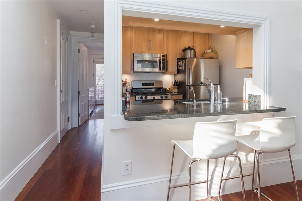 83 Montgomery Street, Unit 2 Boston, MA 02116 - Photo 2 of 11 a kitchen with stainless steel appliances granite countertop a refrigerator and a stove top oven