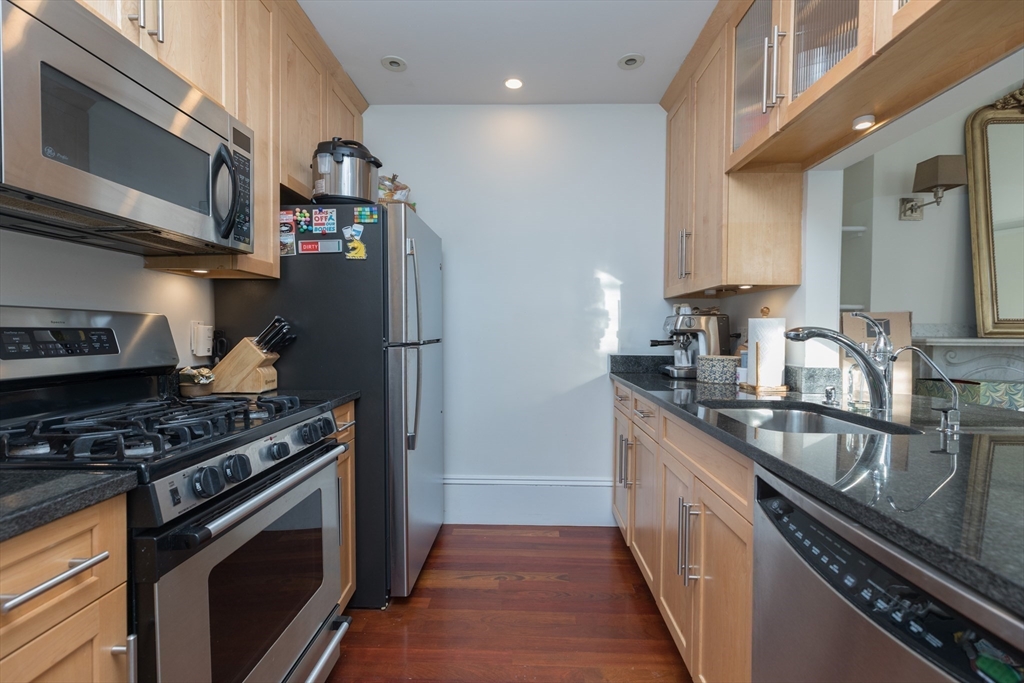 83 Montgomery Street, Unit 2 Boston, MA 02116 - Photo 3 of 11 a kitchen with stainless steel appliances granite countertop a sink a stove and a refrigerator