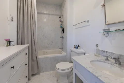 a bathroom with a granite countertop toilet a sink and a bathtub