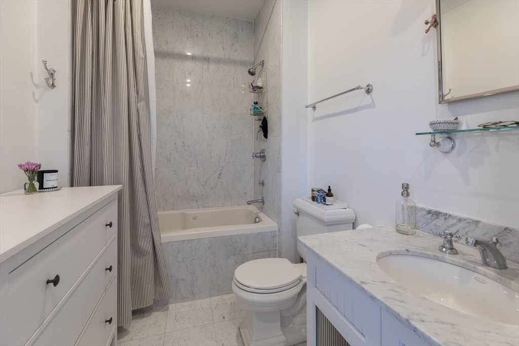 83 Montgomery Street, Unit 2 Boston, MA 02116 - Photo 5 of 11 a bathroom with a granite countertop toilet a sink and a bathtub