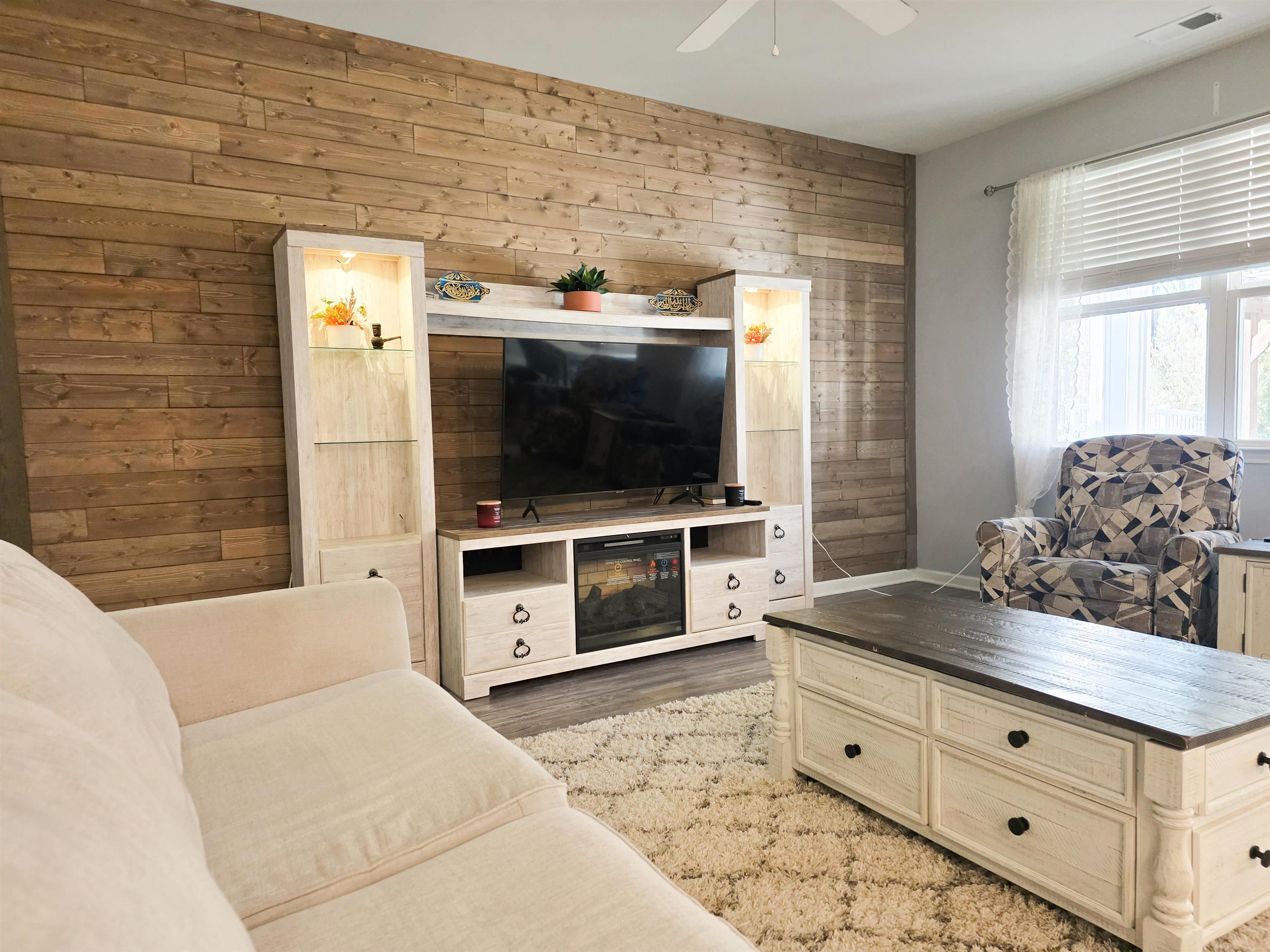 212 Legends Drive Myrtle Beach, SC 29579 - Photo 14 of 18 Living area with wooden walls, a ceiling fan, and light wood-type flooring