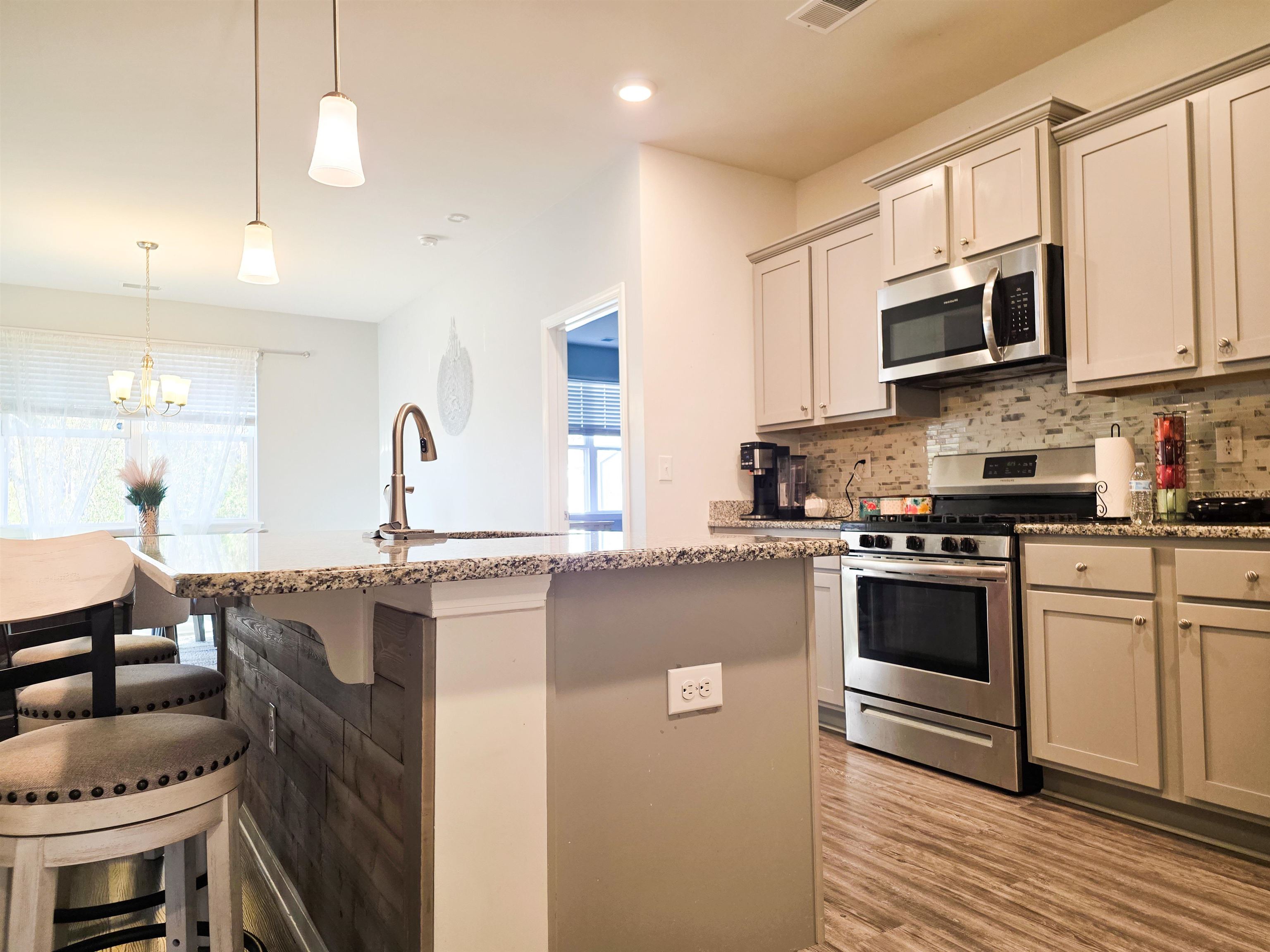 212 Legends Drive Myrtle Beach, SC 29579 - Photo 5 of 18 Kitchen featuring appliances with stainless steel finishes, pendant lighting, backsplash, light stone counters, and recessed lighting