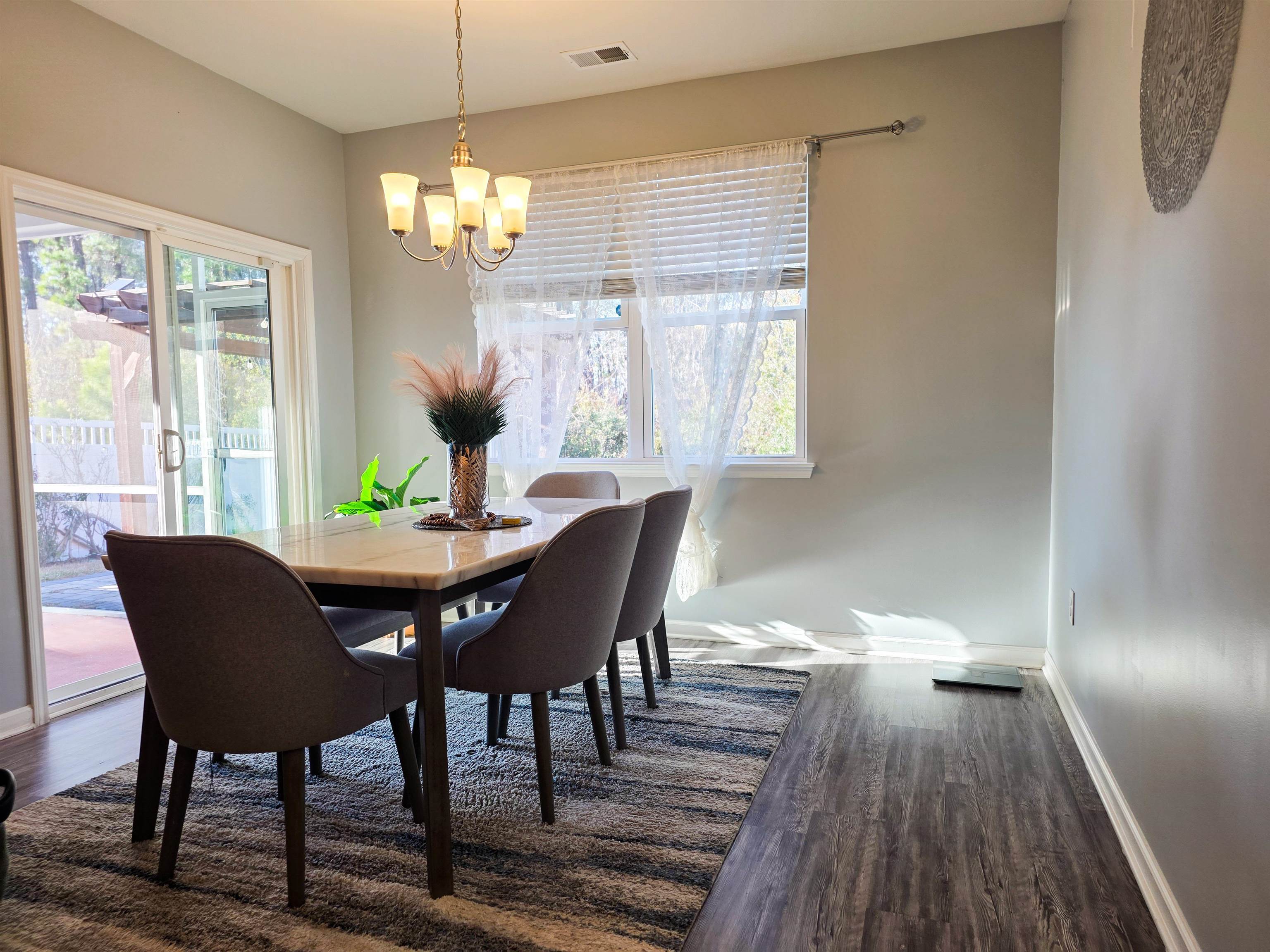 212 Legends Drive Myrtle Beach, SC 29579 - Photo 6 of 18 Dining space with dark wood-type flooring, a chandelier, and plenty of natural light
