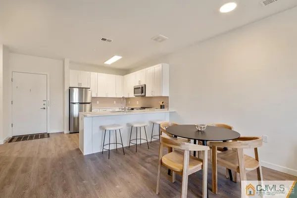 a kitchen with a table chairs stove and cabinets