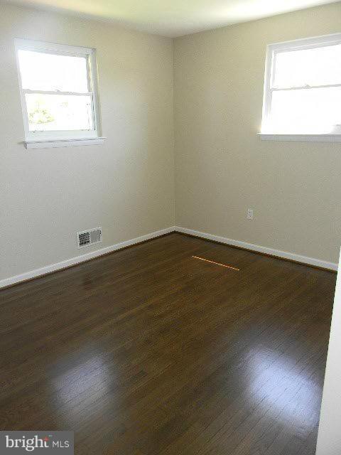 9634 Dundawan Road Baltimore, MD 21236 - Photo 12 of 18 an empty room with wooden floor and windows