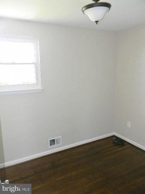 9634 Dundawan Road Baltimore, MD 21236 - Photo 13 of 18 an empty room with wooden floor and windows