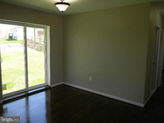 9634 Dundawan Road Baltimore, MD 21236 - Photo 15 of 18 a view of an empty room with wooden floor and a window