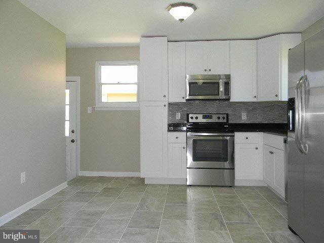 9634 Dundawan Road Baltimore, MD 21236 - Photo 3 of 18 a kitchen with a stove a sink and a microwave