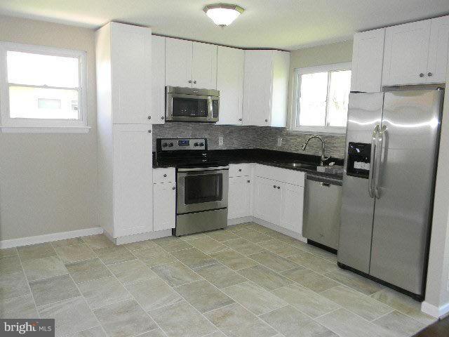 9634 Dundawan Road Baltimore, MD 21236 - Photo 4 of 18 a kitchen with stainless steel appliances granite countertop a stove a sink and a microwave