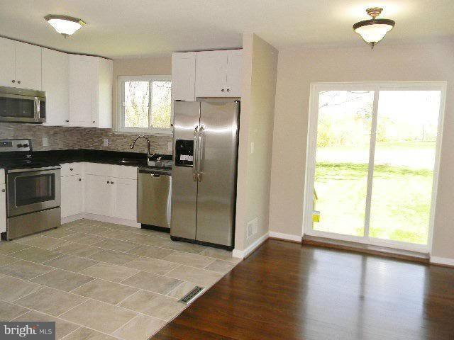 9634 Dundawan Road Baltimore, MD 21236 - Photo 5 of 18 a kitchen with granite countertop a stove a sink and a refrigerator