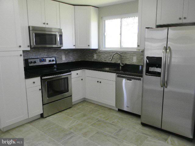9634 Dundawan Road Baltimore, MD 21236 - Photo 6 of 18 a kitchen with granite countertop white cabinets and stainless steel appliances
