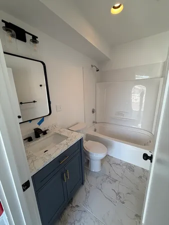 a bathroom with a sink a toilet and tub