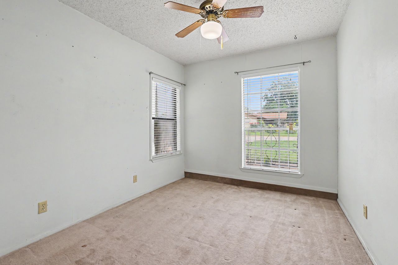 1811 Terry Lane Georgetown, TX 78628 - Photo 33 of 40 A well-lit room featuring two windows with blinds and practical carpeted flooring.