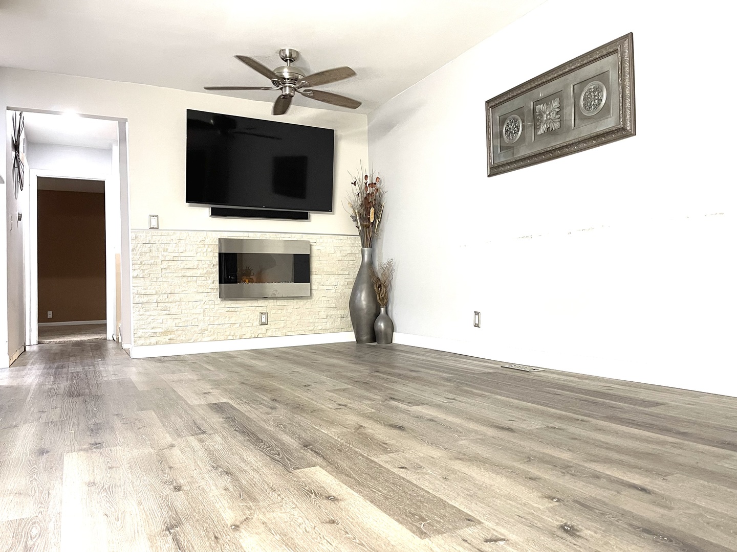1455 Elder Drive Aurora, IL 60506 - Photo 4 of 19 a view of a livingroom with a flat screen tv wooden floor and a ceiling fan
