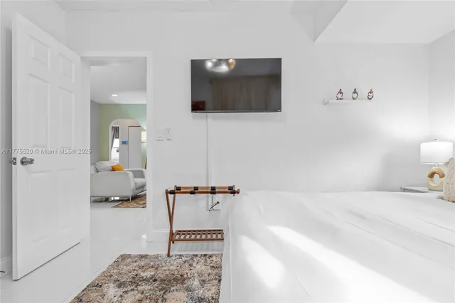 a bedroom with a bed and flat screen tv