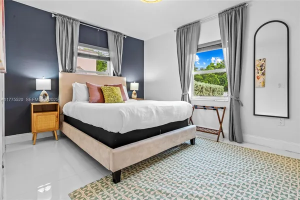a bedroom with a bed lamp and a window