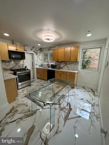 a kitchen with stainless steel appliances kitchen island granite countertop a sink and cabinets
