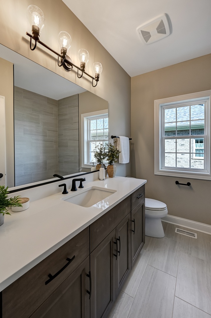12215 Copper Ridge Drive, Unit 13 Lemont, IL 60439 - Photo 18 of 21 a bathroom with a granite countertop sink a toilet and a mirror