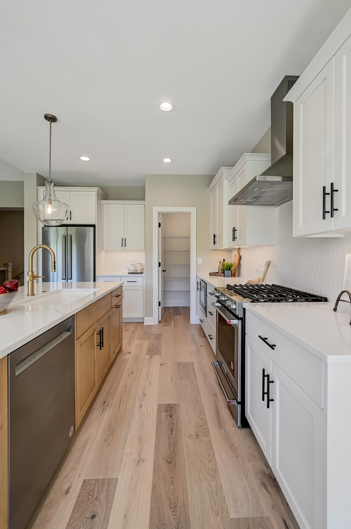12215 Copper Ridge Drive, Unit 13 Lemont, IL 60439 - Photo 10 of 21 a large kitchen with stainless steel appliances lots of counter space and wooden floor