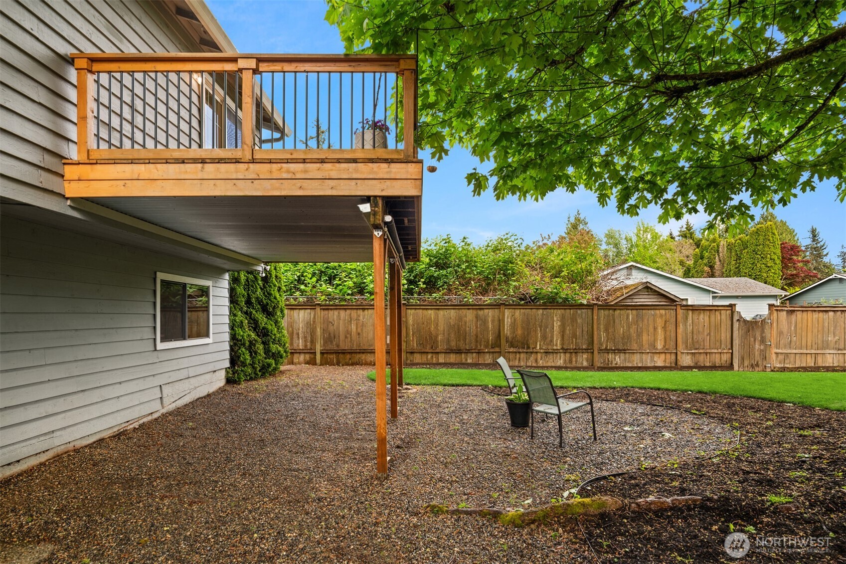 418 212th Street Southwest Bothell, WA 98021 - Photo 33 of 40 a view of a small yard in front of a house with large trees and wooden fence