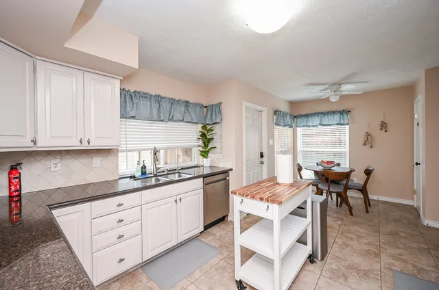 a kitchen with a sink a stove a refrigerator and cabinets