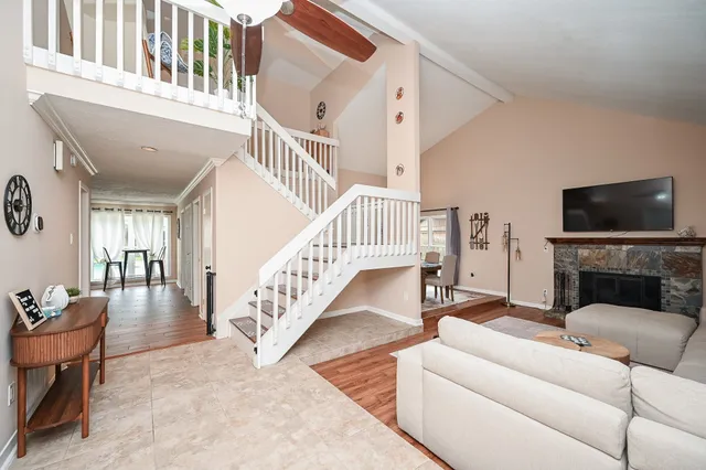 a living room with furniture a fireplace and a flat screen tv