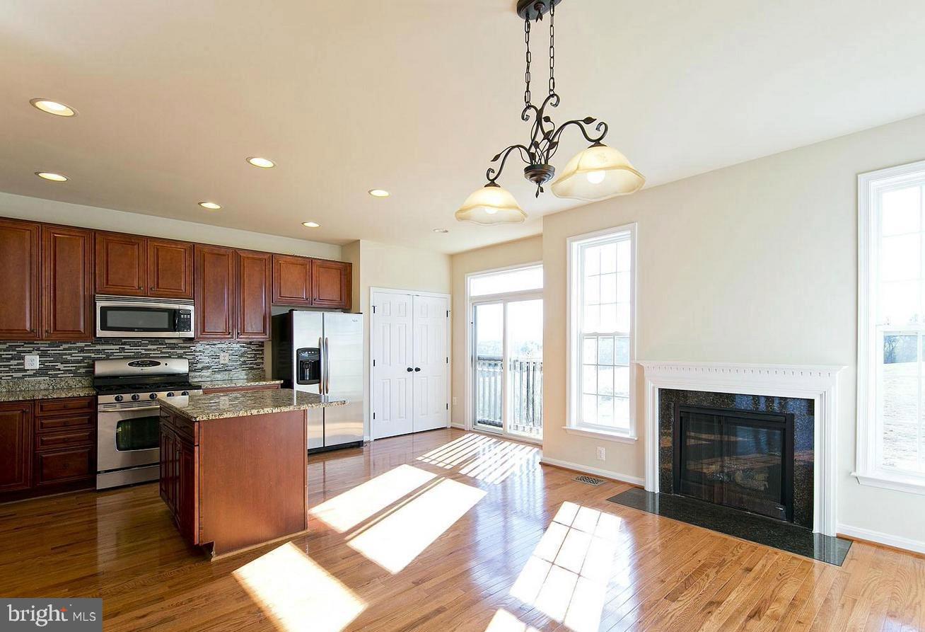 73 Spoon Square Front Royal, VA 22630 - Photo 7 of 28 a large kitchen with stainless steel appliances granite countertop a stove top oven a sink dishwasher and a fireplace with wooden floor