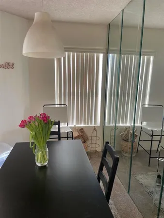 a dining room with furniture and a potted plant