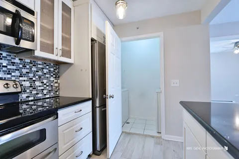 a kitchen with granite countertop a refrigerator and a stove