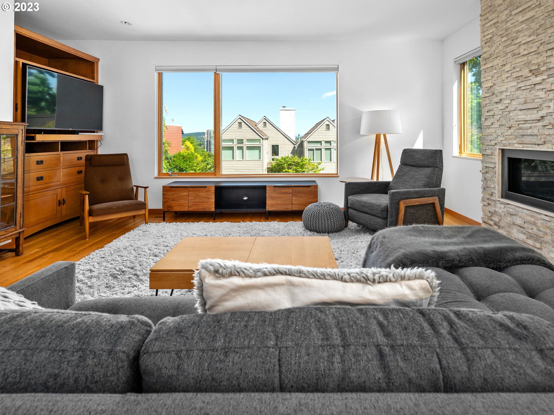 3727 Southwest Condor Lane Portland, OR 97239 - Photo 5 of 33 a living room with furniture flat screen tv and a fireplace