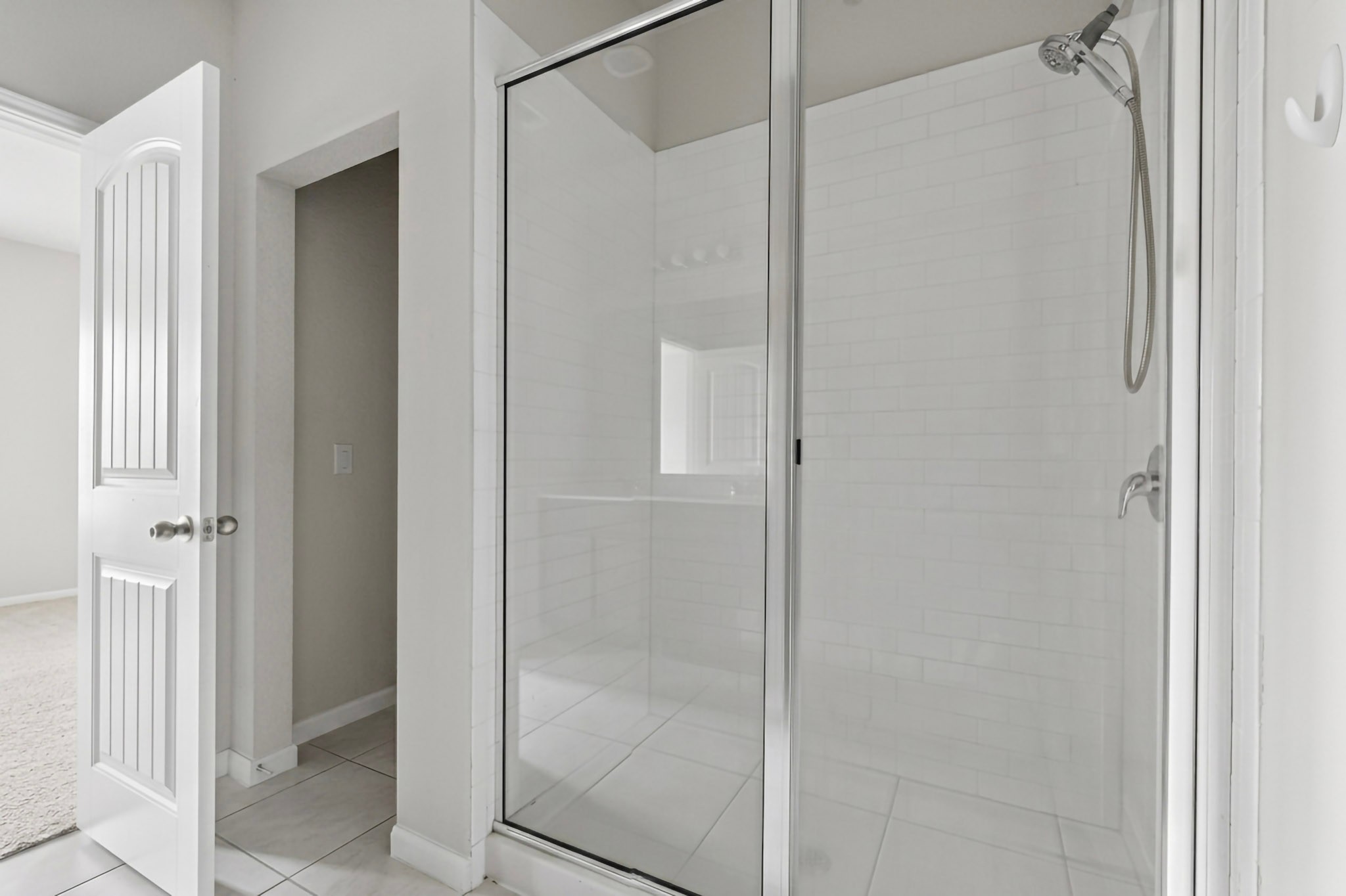 6920 Ranchito Drive Austin, TX 78744 - Photo 8 of 19 A pristine glass-enclosed shower boasts sleek tile walls and flooring, offering a fresh, modern bathing experience.