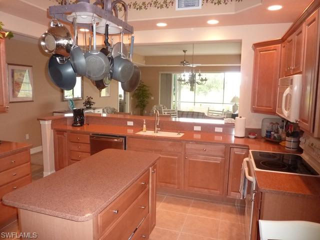 8613 Champions Point, Unit 302 Naples, FL 34113 - Photo 3 of 10 a kitchen with a sink appliances and cabinets