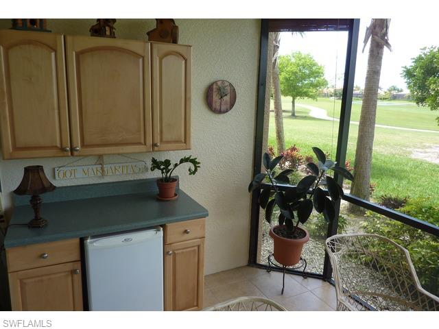 8613 Champions Point, Unit 302 Naples, FL 34113 - Photo 5 of 10 a kitchen with a sink and a view of living room