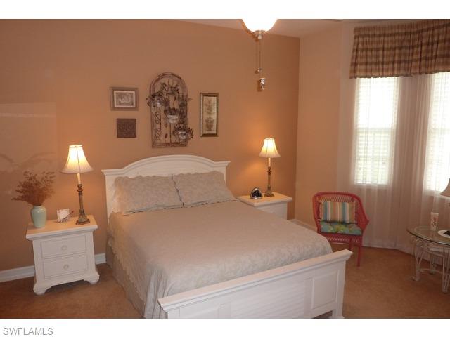 8613 Champions Point, Unit 302 Naples, FL 34113 - Photo 6 of 10 a bedroom with a bed and a lamp