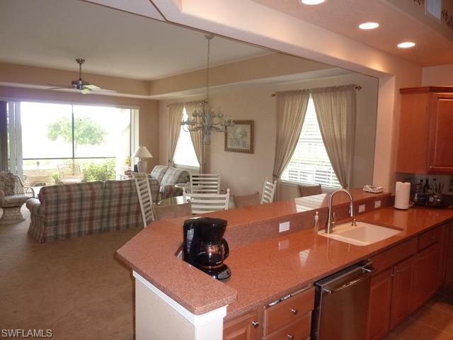 8613 Champions Point, Unit 302 Naples, FL 34113 - Photo 9 of 10 a room with furniture a large window and chandelier