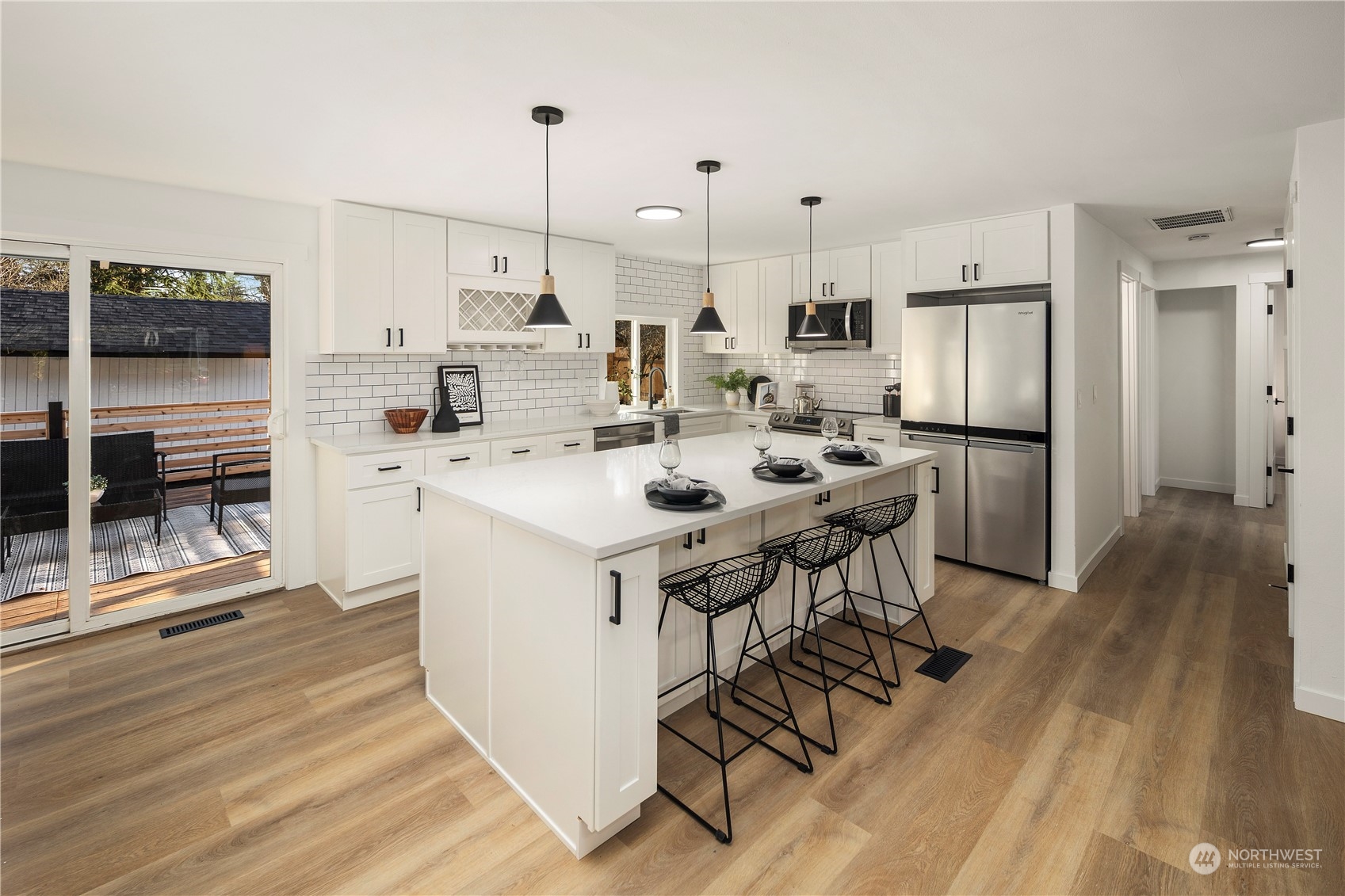 12845 Southeast 258th Street Kent, WA 98030 - Photo 14 of 35 a kitchen with stainless steel appliances kitchen island granite countertop a table chairs stove and a wooden floors