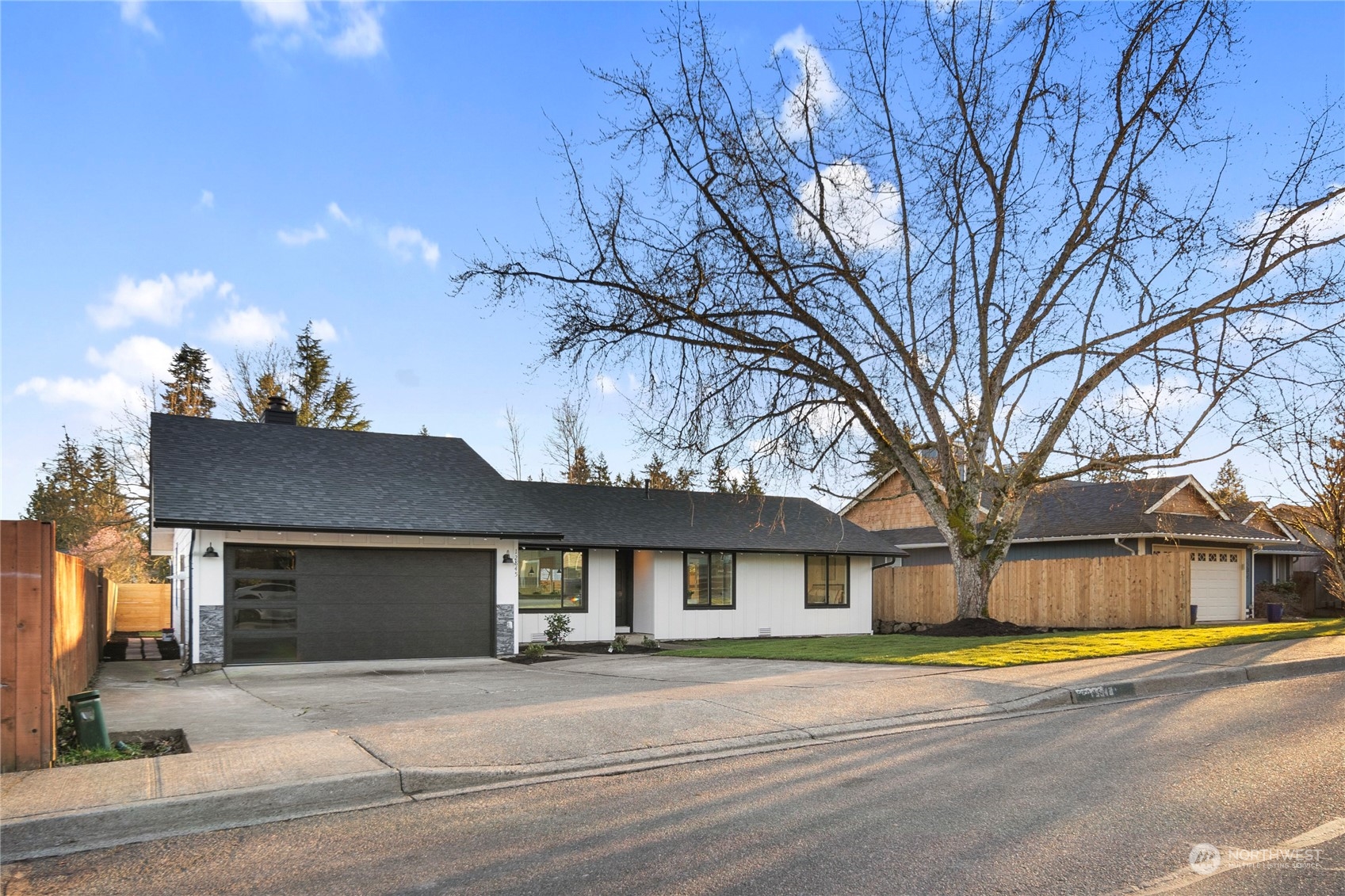 12845 Southeast 258th Street Kent, WA 98030 - Photo 2 of 35 a view of a house with a large tree and a yard