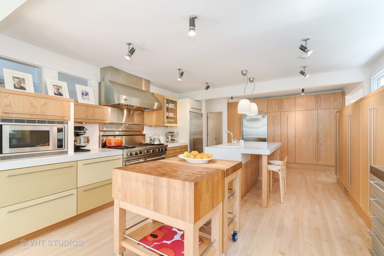 2234 Forestview Road Evanston, IL 60201 - Photo 60 of 76 a kitchen with stainless steel appliances kitchen island granite countertop a stove a sink a dining table and chairs with wooden floor